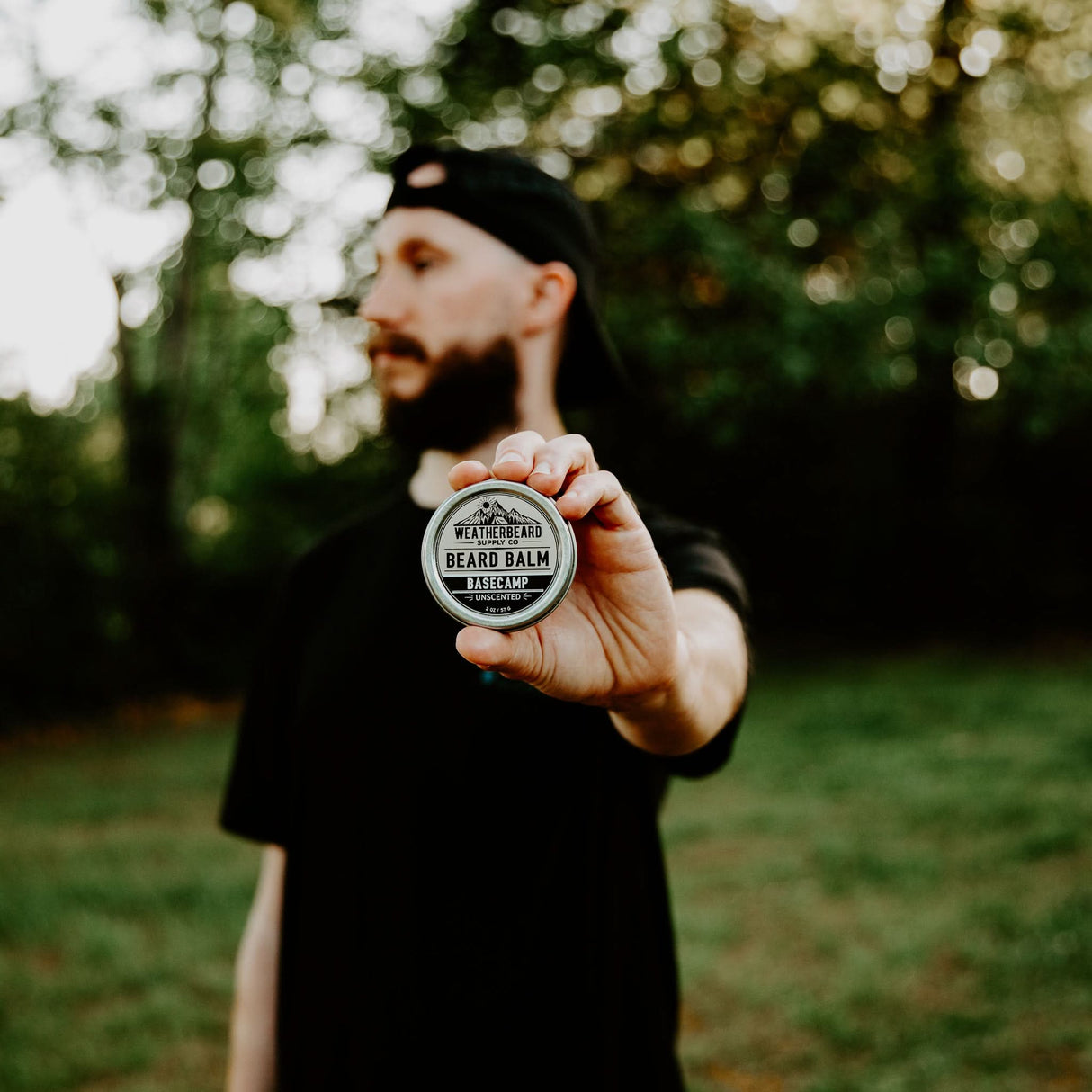 Person holding Weatherbeard Supply Co's unscented and all-natural Beard Balm for styling and shaping the beard
