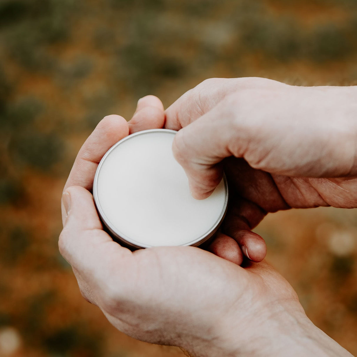 Person scraping Weatherbeard Supply Co Beard Balm out of metal tin