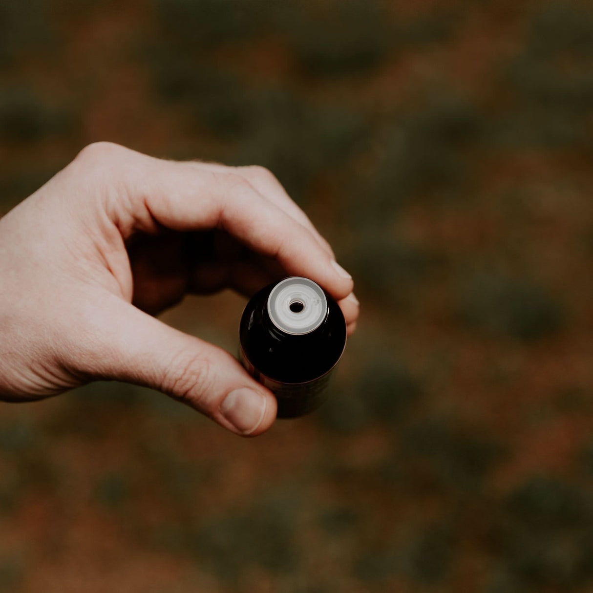 Person holding Weatherbeard Supply Co Beard Oil, showing how the oil pours from bottle