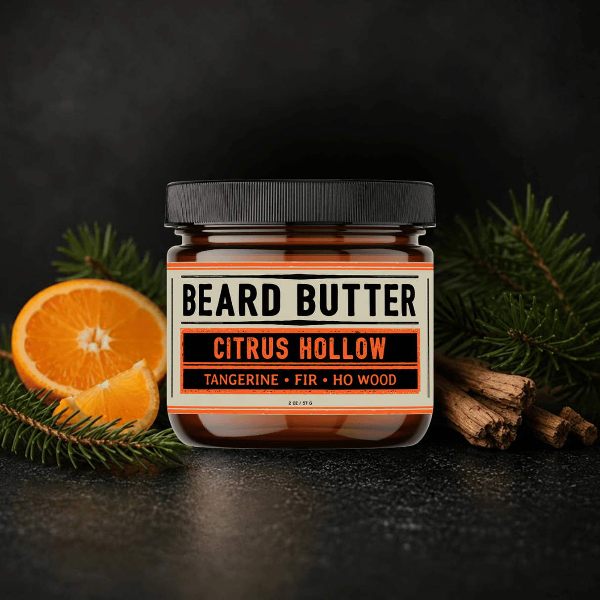 Jar of Citrus Hollow Beard Butter with tangerine slices and fir needle branches on a dark background