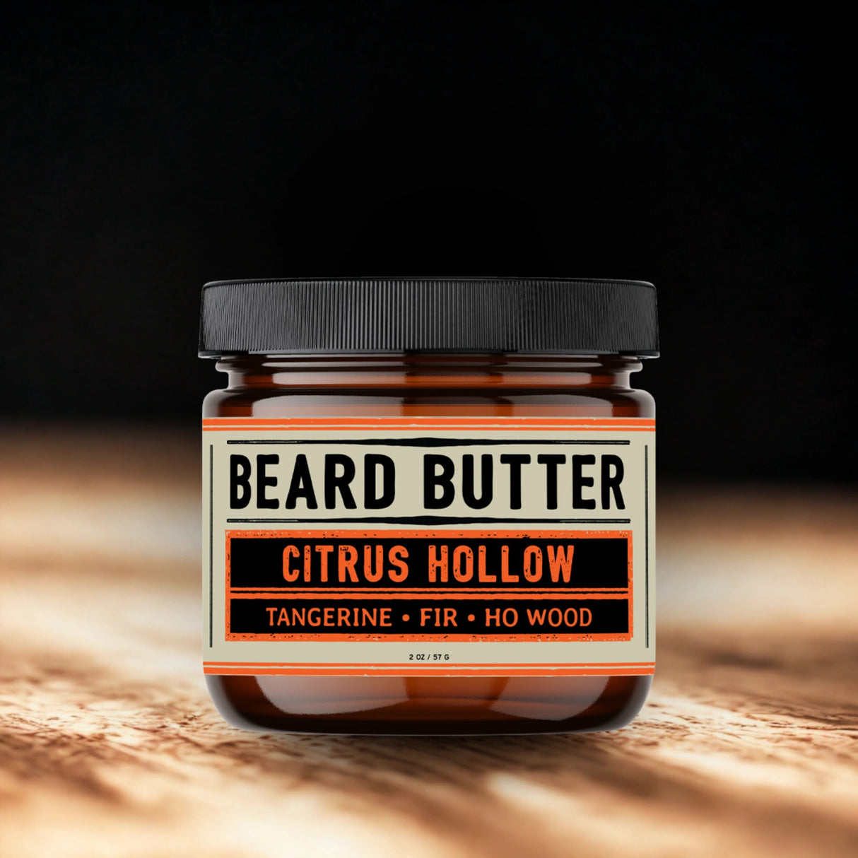 Jar of Citrus Hollow Beard Butter on a wooden surface with a dark background