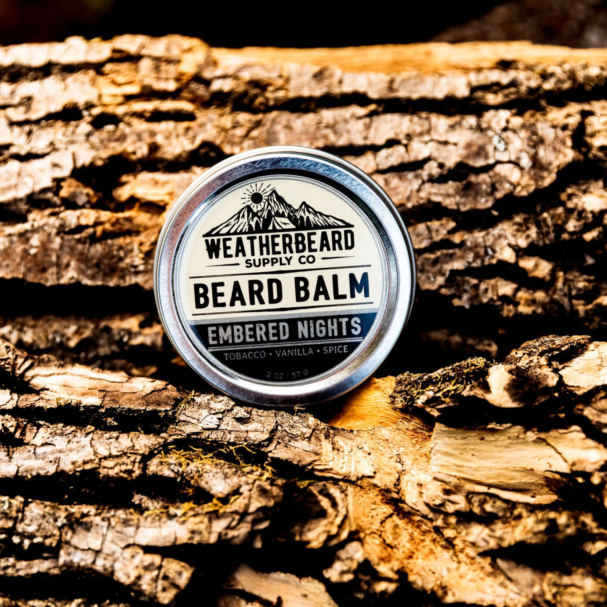 Close up of Embered Nights Beard Balm on firewood