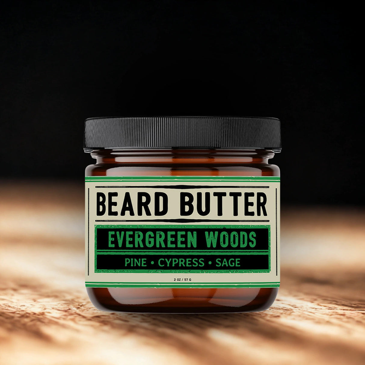 Jar of beard butter labeled 'Evergreen Woods' on a wooden surface with a dark background