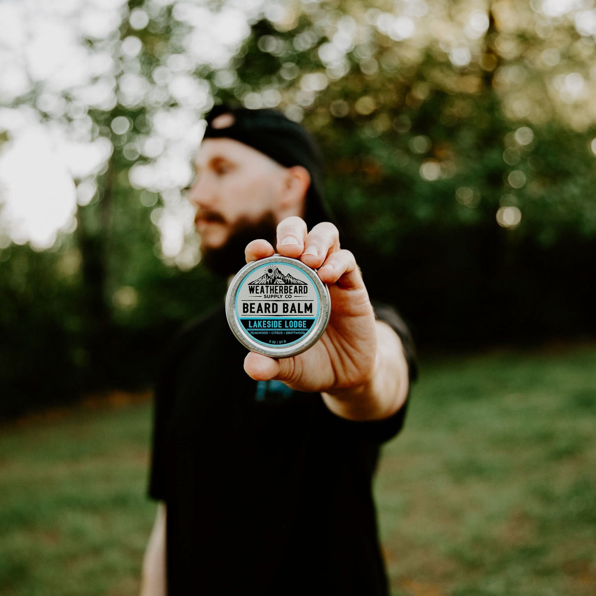 Person holding Lakeside Lodge Beard Balm by Weatherbeard Supply Co, showcasing the product details