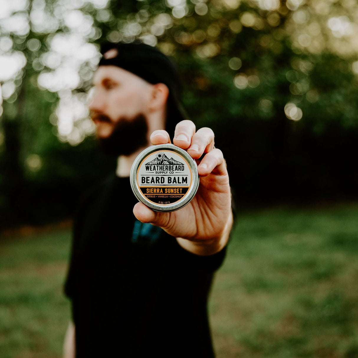 Person holding Sierra Sunset Beard Balm outside in nature