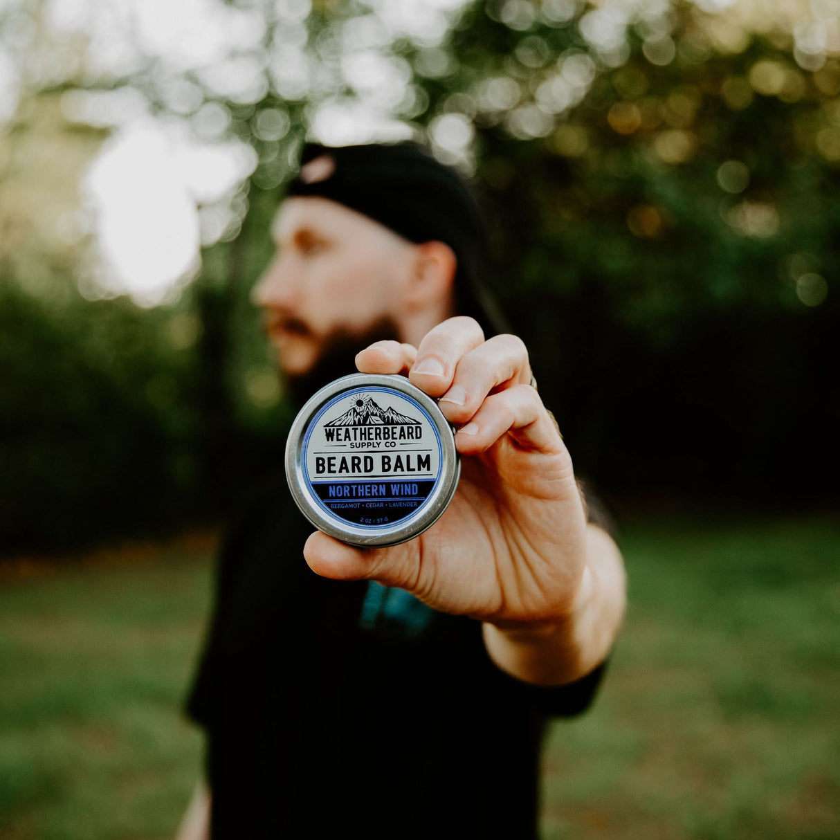 Person holding a Northern Wind Beard Balm outside
