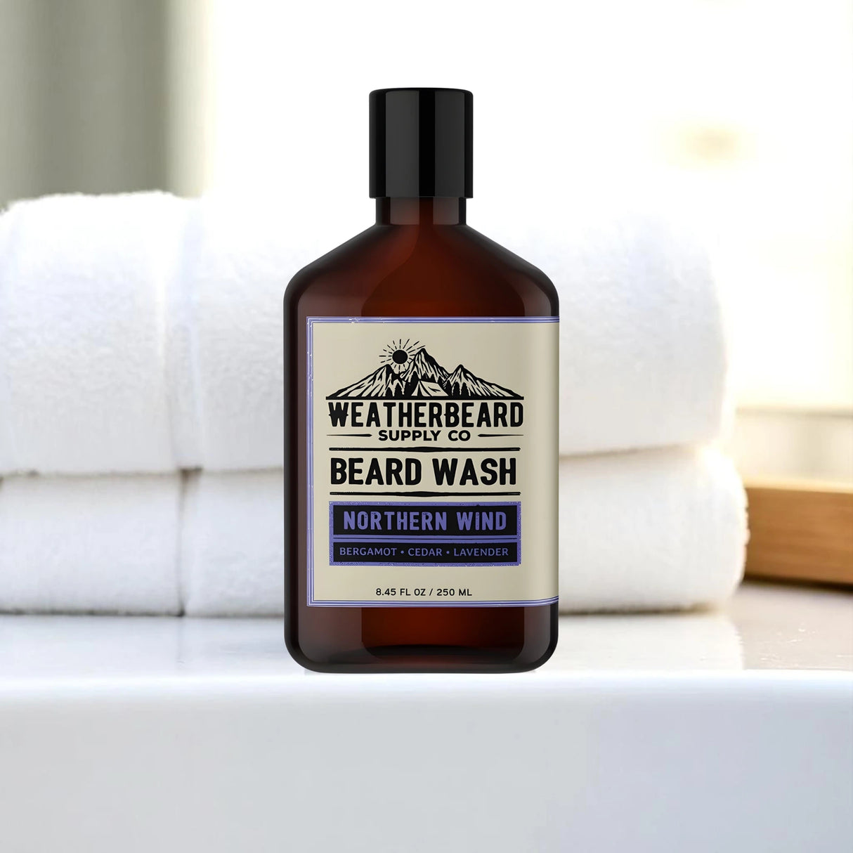 Bottle of Weatherbeard Supply Co. beard on a white bathroom counter with towels in the background