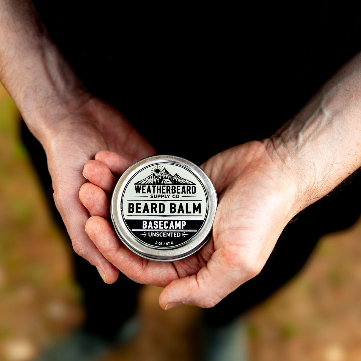Person holding Weatherbeard Supply Co's all-natural and unscented Beard Balm in hand