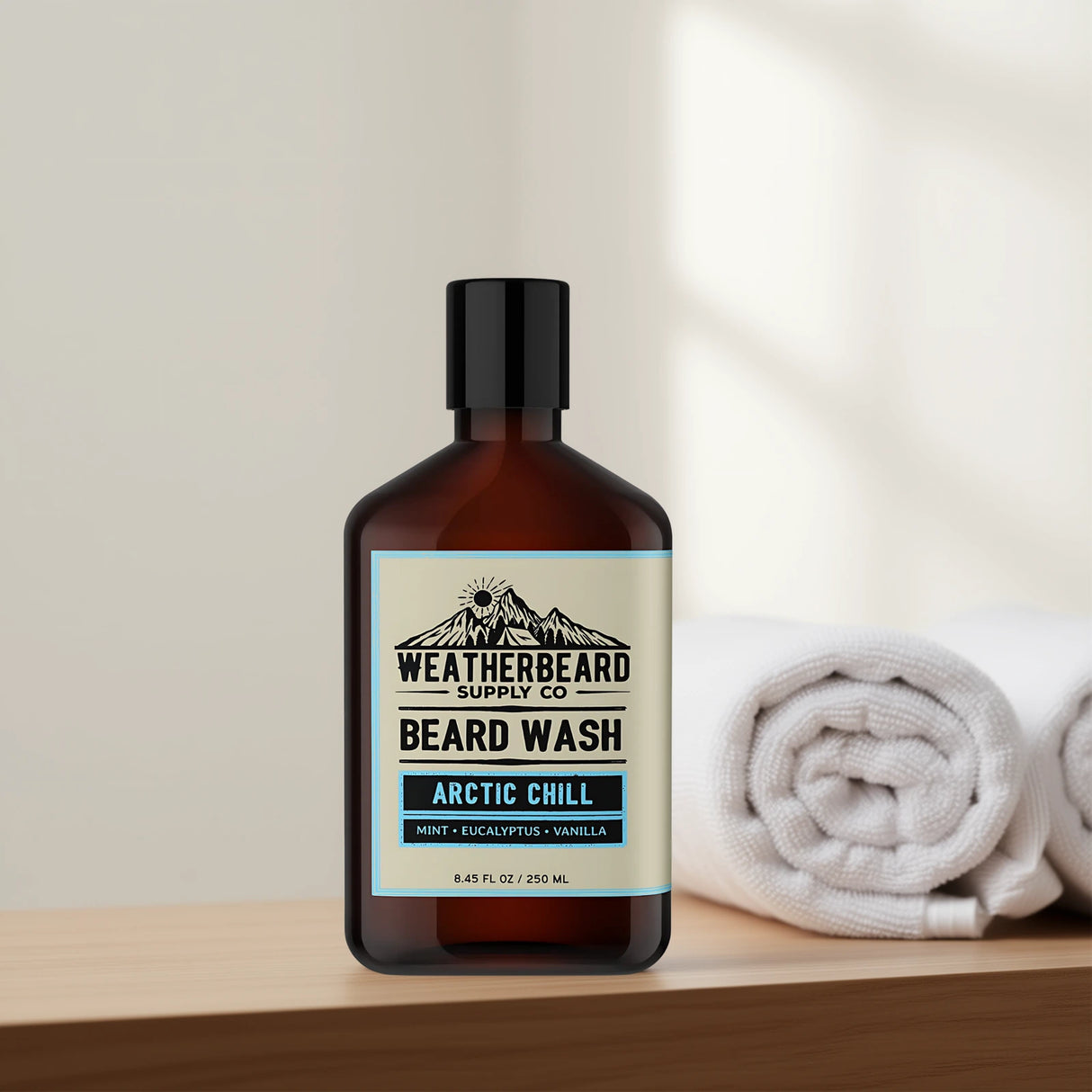 Bottle of Weatherbeard Supply Co.'s Arctic Chill beard wash with a towel in the background on a wooden surface.