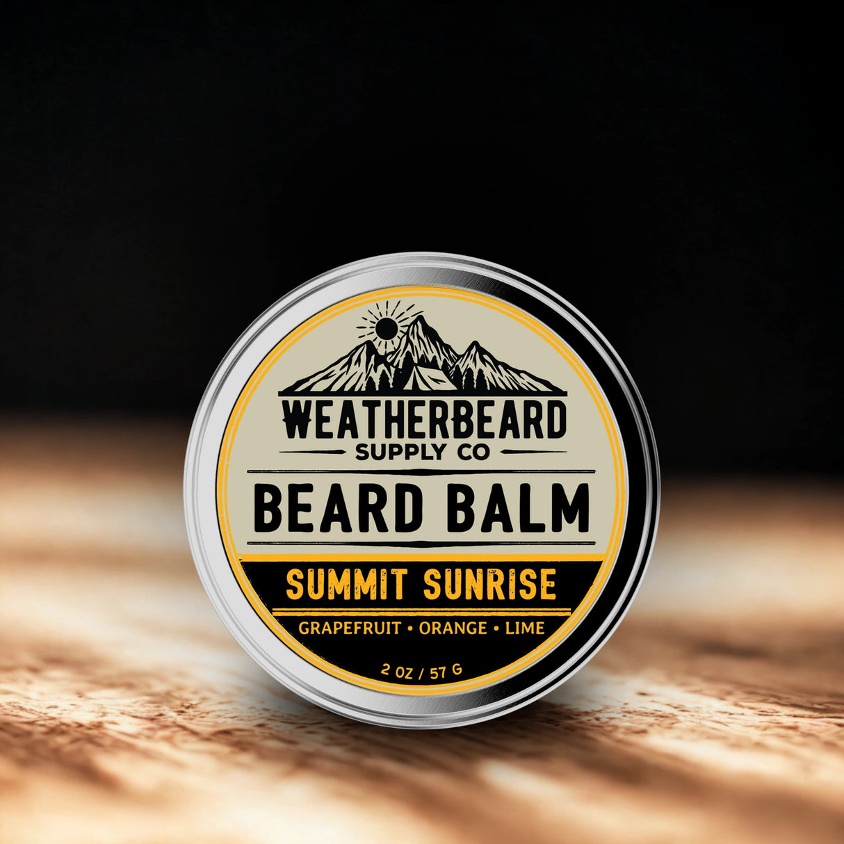 Tin of Weatherbeard Supply Co. Beard Balm Summit Sunrise on a wooden surface with a dark background