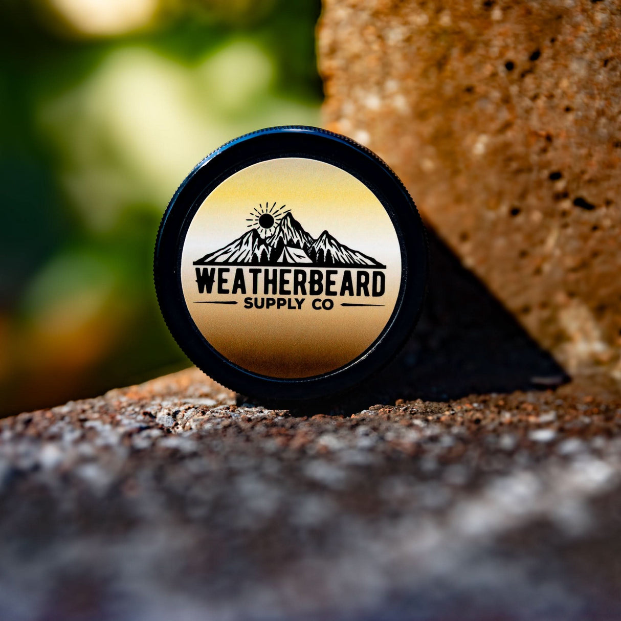 Weatherbeard Supply Co Beard Butter on a textured surface with a blurred natural background