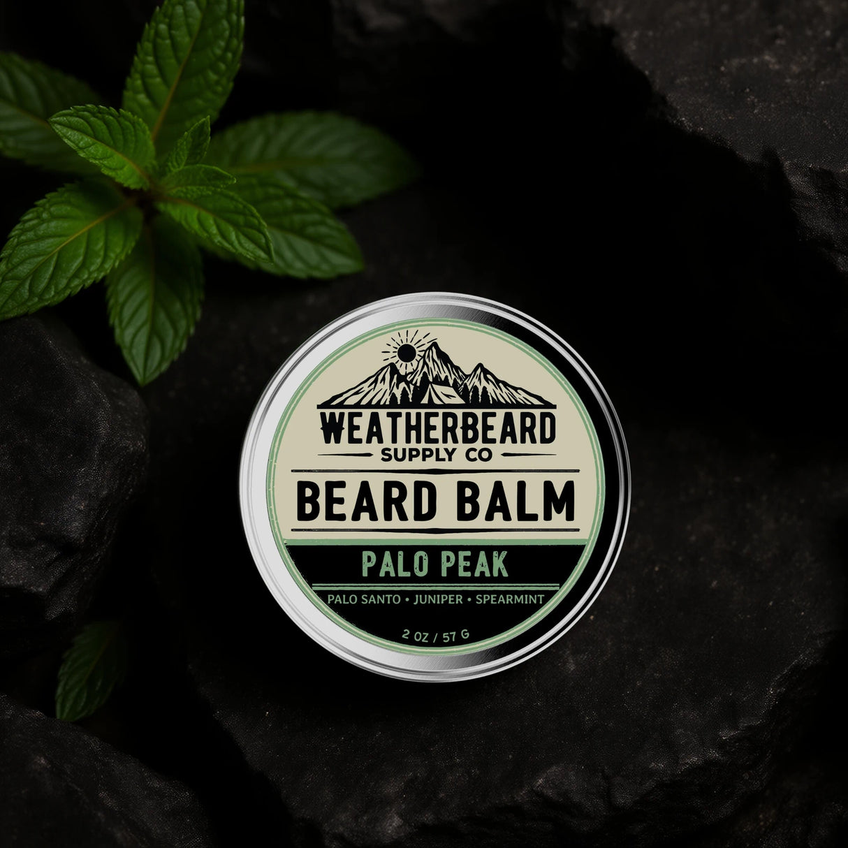 Beard balm container labeled 'Palo Peak' by Weatherbeard Supply Co on a dark stone background with mint leaves.