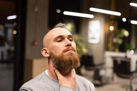 Man touching his beard in barbershop