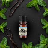 Bottle of Weatherbeard Supply Co. Arctic Chill Beard Oil surrounded by peppermint leaves and vanilla beans