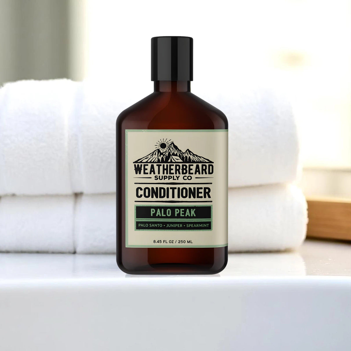 Bottle of Weatherbeard Supply Co beard conditioner on a bathroom sink with towels in background