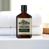 Bottle of Weatherbeard Supply Co beard conditioner on a bathroom sink with towels in background