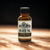 Bottle of Weatherbeard Supply Co. Campside Coffee beard oil on a wooden surface with a dark background