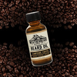 Bottle of Weatherbeard Supply Co. Campside Coffee beard oil surrounded by coffee beans