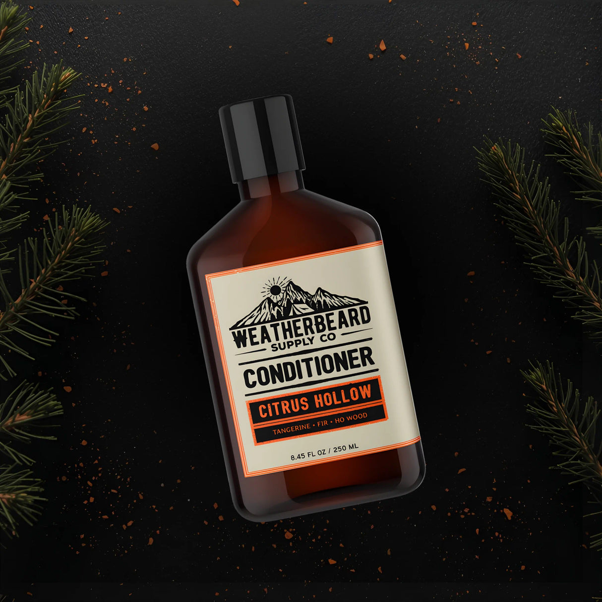 Bottle of Weatherbeard Supply Co. Citrus Hollow Conditioner on a dark background with fir needle branches.