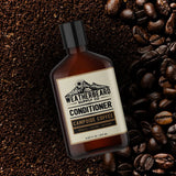 Bottle of Weatherbeard Supply Co Campside Coffee Beard Conditioner surrounded by coffee beans