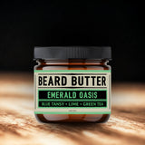 Jar of beard butter labeled 'Emerald Oasis' on a wooden surface with a dark background