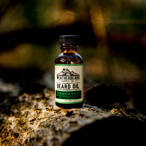 Evergreen Woods Beard Oil by Weatherbeard Supply Co sitting outside in the woods