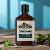 Bottle of Weatherbeard Supply Co. Arctic Chill beard conditioner on a wooden surface with mint leaves.