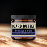 Jar of beard butter labeled 'Northern Wind' on a wooden surface with a dark background