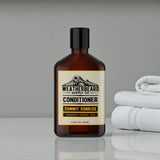 Bottle of Weatherbeard Supply Co. Summit Sunrise beard conditioner with a label, next to folded white towels on a gray background.