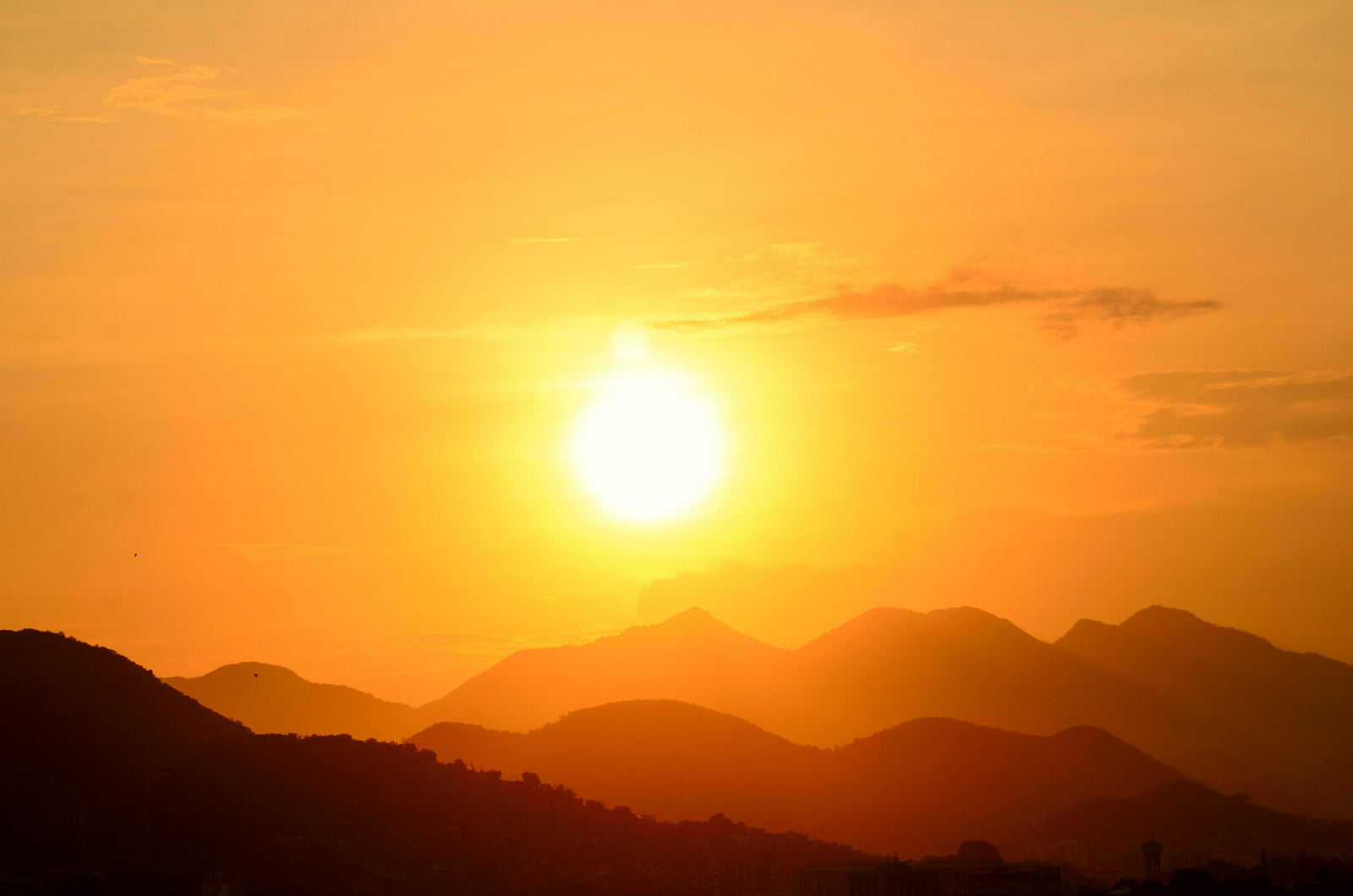 Sunset over mountains with a warm orange and yellow color palette