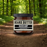 Jar of beard butter labeled 'Basecamp Unscented' in a forest setting