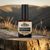 Bottle of Weatherbeard Supply Co's Vetiver Valley Spray Parfum on a wooden tree stump