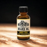 Bottle of Weatherbeard Supply Co Amber Trail Beard Oil on a wooden surface with a dark background