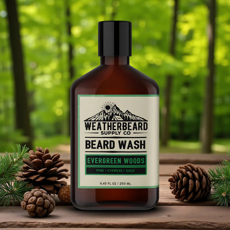 Bottle of Weatherbeard Supply Co. Beard Wash with Evergreen Woods scent on a wooden surface with pine cones and greenery.