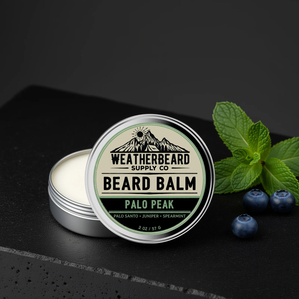 Palo Peak Beard balm container with 'Weatherbeard Supply Co' branding on a dark background with spearmint leaves and juniper berries.