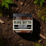 Jar of beard butter labeled 'BASECAMP' on a natural background