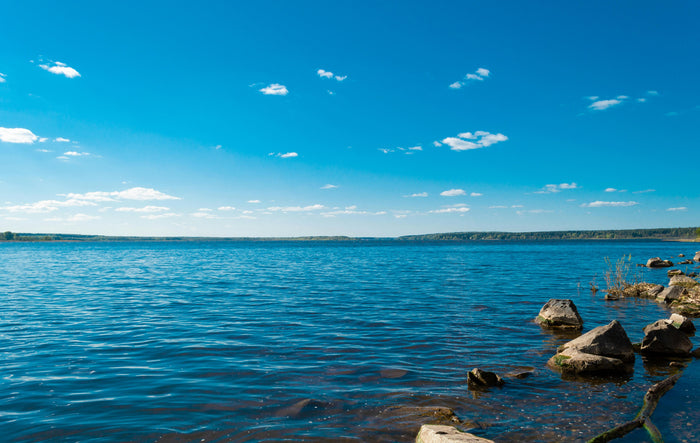 Calm lake with clear blue sky and scattered clouds